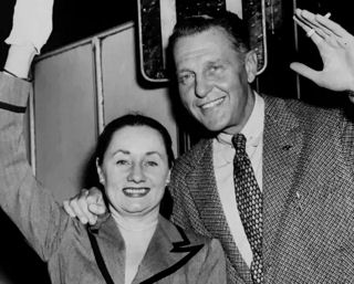  London: Actor Ralph Bellamy and his (4th) wife at Waterloo Station before they left on the Queen Mary boat train at the start of their return trip to their home in America (August 7. 1952).