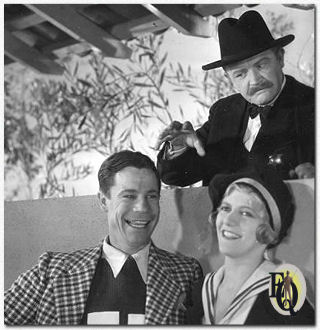 En ze lachten en waren gelukkig, totaal onbewust van de dreiging in de achtergrond. Joe E. Brown en Laura Lee, acteurs in de First National-Vitaphone komedie, "Top Speed." (1930). Het gevaar werd voorzien door Wade Boteler.