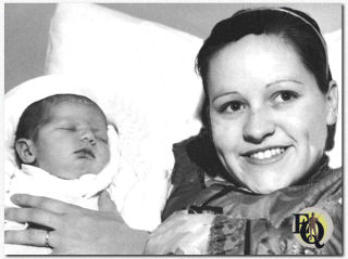 Donna Daily Cook, 4 days old, daughter of Donald Cook, film actor, and his wife, the former Maxine Dailey Lewis, singer, was more interested in getting her full quota of sleep than in such things as picture taking when she was photographed with her mother in a Hollywood Hospital (May 26. 1934)