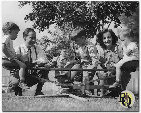 Tough guy is family man: Harry Morgan, usually a tough guy in movies, is quite a family man. All his spare time is spent playing with fours sons in the back-yard playground of the Morgans' San Fernando Valley home. In the photograph, Harry and his wife give their twins a ride while two older sons discuss football. The twins are Danny (L) an Paul, in the other seat. Chris, 6 1/2 years old, holding the ball, and Timmie, 5, make plans for a catch. (1949)