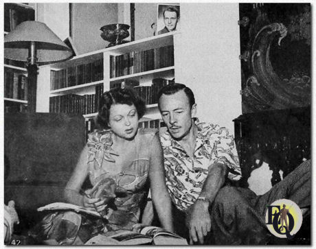 The secret of a successful marriage, say these two - who have one - is sharing. Les and Alice share both work and hobbies, foremost among the latter being archeology. (Note: notice the picture of Ralph Bellamy in the background)