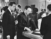 Ray Stafford (Morgan Conway) shows his upstairs, private gambling casinot to Ellery Queen (William Gargan). Later Conway played Dick Tracy in two movies.