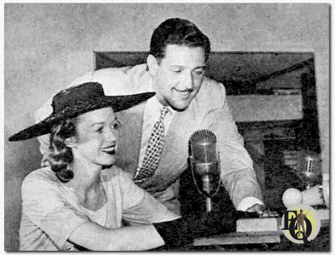 "Quick as a Flash" EMCEE KEN ROBERTS shows fair contestant how to work the buzzer and tells her rules of broadcast. Every one of the six guests has an equal chance at the questions, may participate as often as he wishes. ("Radio Life", January 1945)