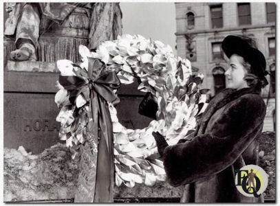 Famous American journalist honored New York - Gertrude Warner, star of CBS program "City Desk", lays a wreath on Horace Greeley's statue in City Hall Park, commemorating the 130th Anniversary of the birth of the famous American Journalist. (2-3-1941)